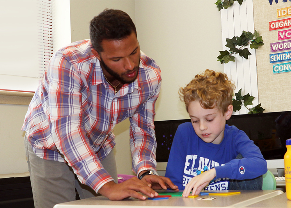 Student teacher helps student with an assignment at The College School